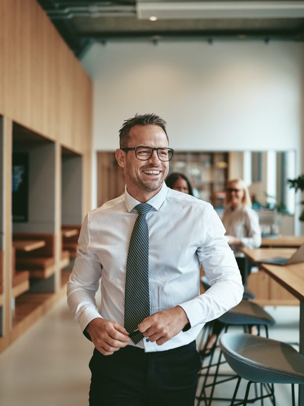 mature-businessman-laughing-while-walking-through-a-modern-office.jpg